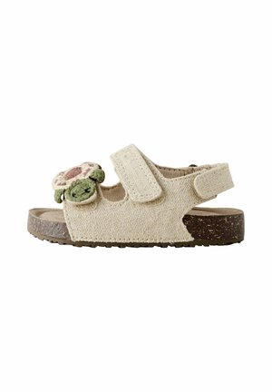 Beige Kleinkind-Sandale mit verstellbaren Riemen, verziert mit einem grünen und pinken Schildkrötenapplikation auf der Vorderseite und einer strukturierten braunen Sohle.
