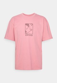 T-shirt rose à manches courtes avec un dessin au trait noir représentant deux visages s'embrassant à l'intérieur d'un rectangle, accompagné d'un texte de style japonais sous l'œuvre.