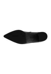 Chaussure noire à bout pointu avec un dessus en cuir lisse et une semelle en caoutchouc texturée. Elle présente un design à enfiler pour un enfilage facile.