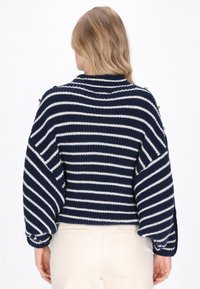 Navy- und weiß gestreifter Strickpullover mit lockerer Passform, weiten Ärmeln und Knopfakzenten an den Schultern. Strukturiertes Garn.