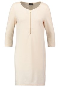 Sukienka z krepy w jasnym beżu z okrągłym dekoltem i rękawami o długości trzech kwart, z złotym zamkiem z przodu jako zapięciem.