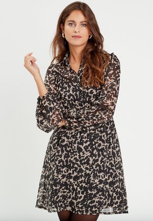 Abito trasparente a maniche lunghe con stampa animale nera e beige, dotato di colletto e dettaglio delle maniche arricciate.