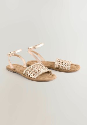 Platta sandaler med en metallic roséguldfinish, med ett vävt ovandel och ankelrem, på en fotbädd av tanmocka.