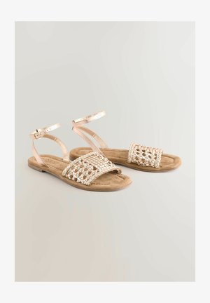 Platta sandaler med en metallic roséguldfinish, med ett vävt ovandel och ankelrem, på en fotbädd av tanmocka.