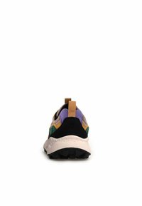 Sneaker multicolore con pelle scamosciata nera, accenti beige e viola, suola testurizzata e un'etichetta sul retro per indossarla facilmente.