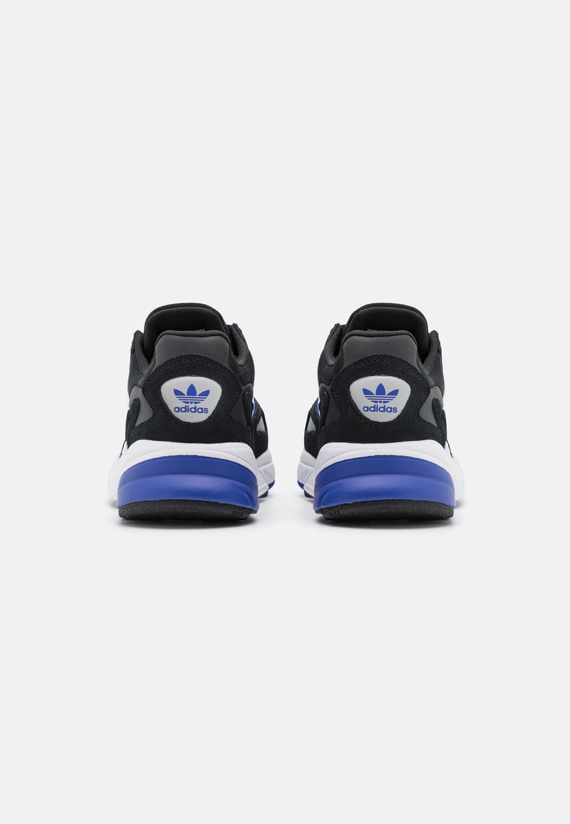 Czarne buty sportowe z białą podeszwą i niebieskimi akcentami. Posiadają teksturowaną powierzchnię i wyścielony kołnierz. Logo Adidas na pięcie.