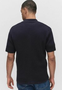 Korte mouwen polo shirt, donkermarine kleur, gestructureerd gebreid patroon, ribgebreide kraag en zoom, met een rechte snit en een ontspannen pasvorm.