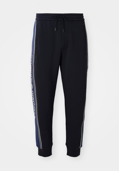 Pantaloni de jogger negri cu dungi laterale albastre, talie elastică cu șnur, buzunare laterale și manșete ribbate la gleznă.