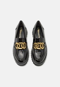 Mocasines de charol negro con acento de cadena dorada, punta redondeada y suela de goma gruesa. Talla 37, con textura suave y diseño minimalista.