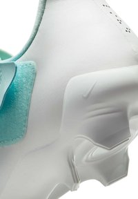 Nike sneaker sima fehér felsőrésszel, világoskék akcentusokkal, texturált sarkával és minimalista dizájnnal. Diszkrét márkajelzéseket tartalmaz.