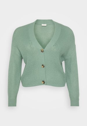 Mint green knitted cardigan with a v-neck, long sleeves, and three brown buttons down the front. Textured fabric, cropped design.