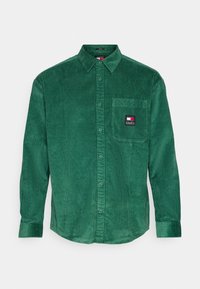 Zelená manšestrová košile s límečkem na knoflíky, dlouhými rukávy, náprsní kapsou s logovou nášivkou a texturovaným žebrovaným vzorem.