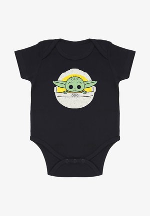 Zwarte babypak met een afbeelding van een groene, cartoonachtige figuur met grote ogen en oren, omringd door een gele cirkelvormige afbeelding.