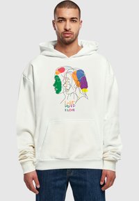 Felpa bianca con cappuccio caratterizzata da un design astratto colorato che rappresenta molteplici volti e dalla frase "L'AMORE È AMORE" in lettere vivaci. Realizzata in un tessuto morbido.