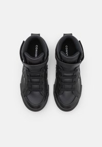 Czarne sneakersy typu high-top wykonane z gładkiej sztucznej skóry, z wiązanym przodem, zapięciem na rzep, wyściełanym kołnierzem i kontrastowymi detalami w ściegach.