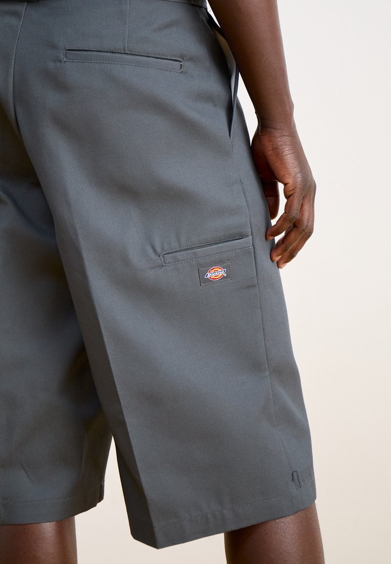 Pantaloni corti grigi realizzati in tessuto resistente, dotati di una tasca posteriore con una patch logo, vestibilità slim e orlo dritto.
