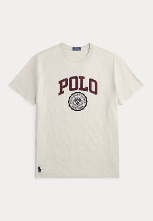 T-shirt gris clair à manches courtes et col rond avec "POLO" en grandes lettres bordeaux et un emblème circulaire Polo Ralph Lauren New York en dessous.