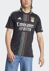 Maglietta sportiva nera con testo bianco "Emirates Fly Better", caratterizzata da strisce verticali colorate e logo ricamato sul petto. Maniche corte.
