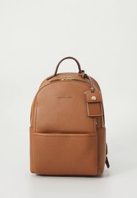 Tanfarget skinnryggsekk med rund form, gylne metallbeslag, topphåndtak, frontlomme og merkebrikke. Har teksturert materiale og sydd dekor.