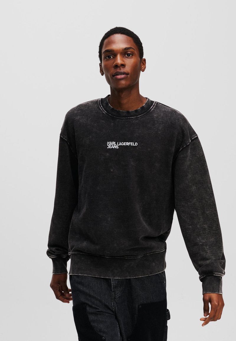 Sort, oversized sweatshirt med rund halsudskæring, der har hvid "KARL LAGERFELD JEANS" tekst på brystet og tekstureret stoffinish.