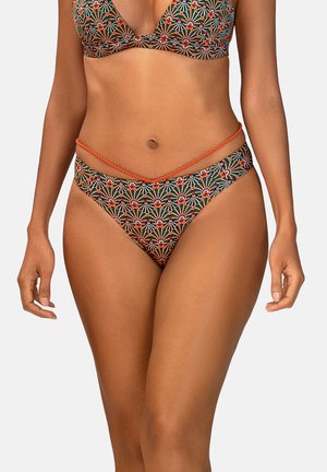 Kobieta w bikini w zielono-pomarańczowo-białe kwiatowe wzory z pomarańczowym skręconym sznurem przy biodrach na białym tle.