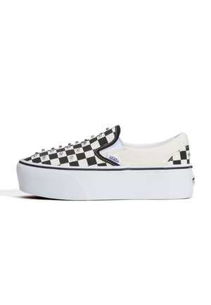Nízka platformová slip-on obuv Vans s čierno-bielym kockovaným vzorom a kovovými nitmi na zvršku.