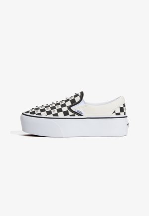 Nízka platformová slip-on obuv Vans s čierno-bielym kockovaným vzorom a kovovými nitmi na zvršku.
