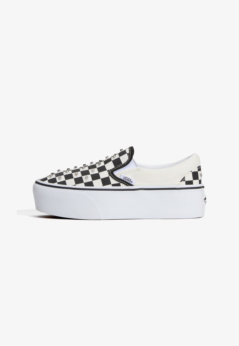 Slip-on παπούτσι Vans με χαμηλή σόλα, μοτίβο ασπρόμαυρου καρό και μεταλλικά καρφιά στο επάνω μέρος.