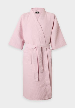 Peignoir rose clair à texture gaufrée, manches courtes, poches avant et ceinture à nouer à la taille sur un fond clair uni.