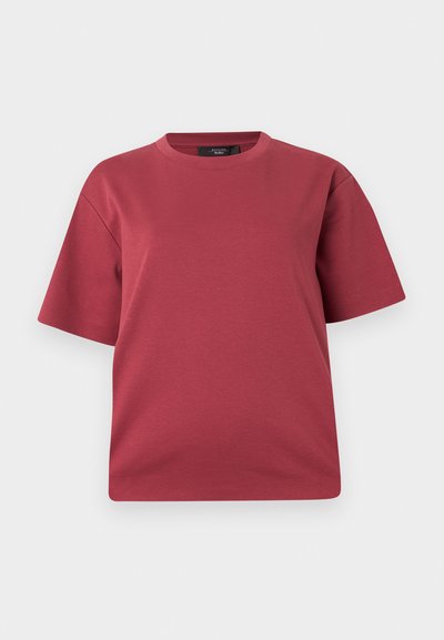 T-shirt à manches courtes et col rond couleur rose poudré avec une coupe décontractée, présenté sur un fond blanc uni.