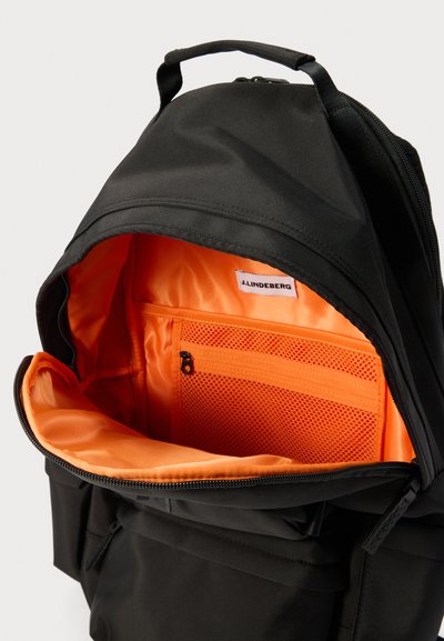 Μαύρο σακίδιο με επάνω λαβή, ανοιχτό για να φαίνεται η φωτεινή πορτοκαλί επένδυση εσωτερικά και η εσωτερική τσέπη από δίχτυ με φερμουάρ.