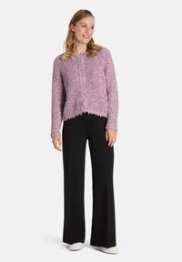 Leichter, rosa gestrickter Cardigan mit strukturiertem Design, ergänzt durch einen rohen Saum und eine cropped Passform, kombiniert mit schwarzen weit geschnittenen Hosen.