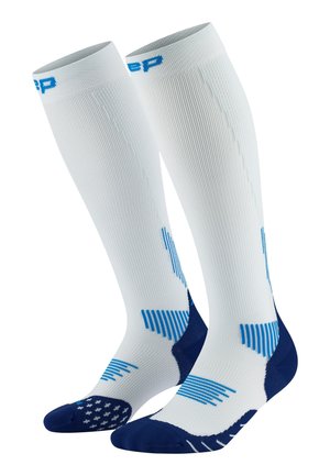 Knee-high compression socks in white and navy, featuring textured patterns, blue accents, and a reinforced toe for support and durability.