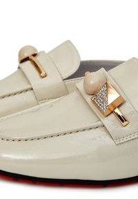 Weiße Lederloafers verfügen über einen goldfarbenen Akzent mit einer Perle und Kristalldetails. Die Sohle ist rot mit einer glatten Oberfläche.
