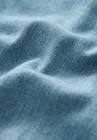 Heledsinine denimkangas pehme tekstuuriga, kuvatud õrnade voltidega ja peene kootud mustriga. Kerge ja mitmekülgne materjal.