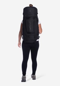 Zwarte wandelrugzak met gewatteerde schouderbanden en verstelbaar hardware. Grote hoofdcompartiment met bovenklep, gestructureerde stof en branding.