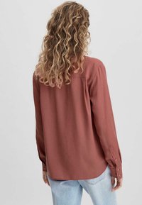Langärmliges Hemd in staubigem Rosé, aus weichem Stoff, mit geradem Schnitt, Knopfmanschetten und einem Rückeneinsatz.