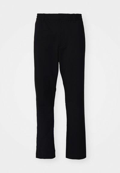 Svarta byxor med slim fit. De har resårmidja och raka ben, tillverkade av ett slätt tyg med matt yta.