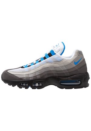 Sportieve sneaker met witte, grijze en zwarte lagen, blauwe accenten, zichtbare luchtvering en een blauwe Nike-swoosh op de hiel.