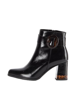 Musta nahkasaapas nilkkamallilla, jossa on paksu korko, kilpikonnakuosiset yksityiskohdat, pyöreä solki ja sivuvetoketju.