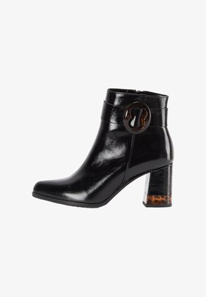 Musta nahkasaapas nilkkamallilla, jossa on paksu korko, kilpikonnakuosiset yksityiskohdat, pyöreä solki ja sivuvetoketju.