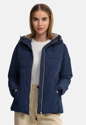 Navy puffer jacket with a hood, featuring a beige inner lining, quilted texture, copper hardware accents, and front pockets.