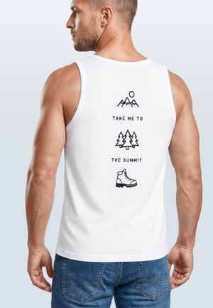 Mann von hinten, trägt ein weißes Tanktop mit Berg-, Baum- und Stiefelsymbolen und dem Text „Bring mich zum Gipfel“ auf dem Rücken.