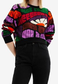 Farverig grafisk sweatshirt i sort med fed tekst i rød, grøn, lilla og orange. Ribstrikkede manchetter og kant giver tekstur og struktur.