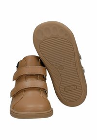 Brązowe skórzane buty dla maluchów z podwójnymi paskami na rzepy i gumową podeszwą z teksturowanym bieżnikiem. Gładkie wykończenie z kontrastującymi przeszyciami.