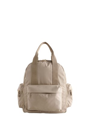 Mochila beige con dos asas superiores, bolsillo frontal con cremallera y dos bolsillos laterales con cremallera sobre un fondo blanco.