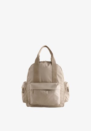 Mochila beige con dos asas superiores, bolsillo frontal con cremallera y dos bolsillos laterales con cremallera sobre un fondo blanco.