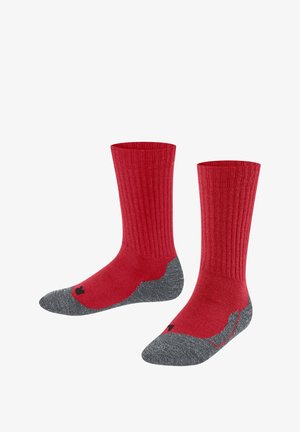 Chaussettes rouges en équipe avec texture côtelée et renfort gris au niveau des orteils et du talon. Détail du logo noir près de la base. Matériau doux pour le confort.