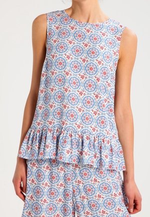 Top à imprimé floral en bleu, rouge et blanc avec un col rond, sans manches et un ourlet volanté. Présente des motifs circulaires sur l'ensemble.