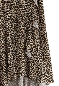 Tessuto leopardato con motivo beige e nero; dettaglio con bordi arricciati; texture morbida; design a strati.